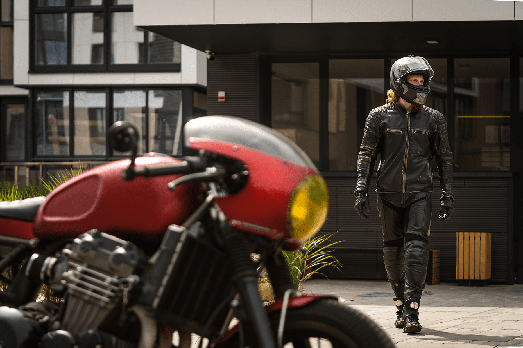 A man walking towards a motorcycle