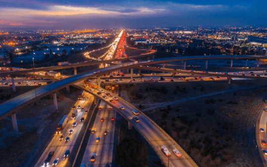 a highway with cars in the city at night